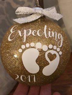 an ornament that says expecting 2013 on it with a baby's foot