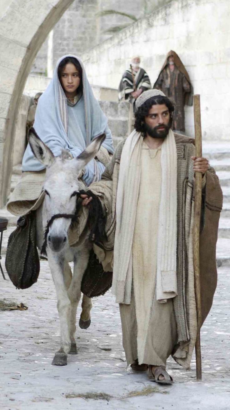 a man and woman are walking with a donkey