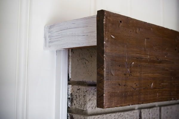 a close up of a wooden shelf on the side of a wall with white paint