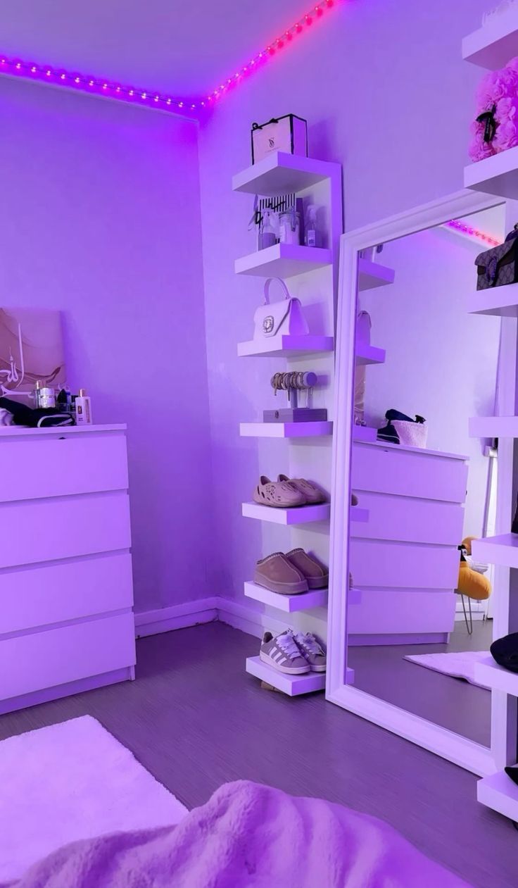 a bedroom with purple lighting and white furniture