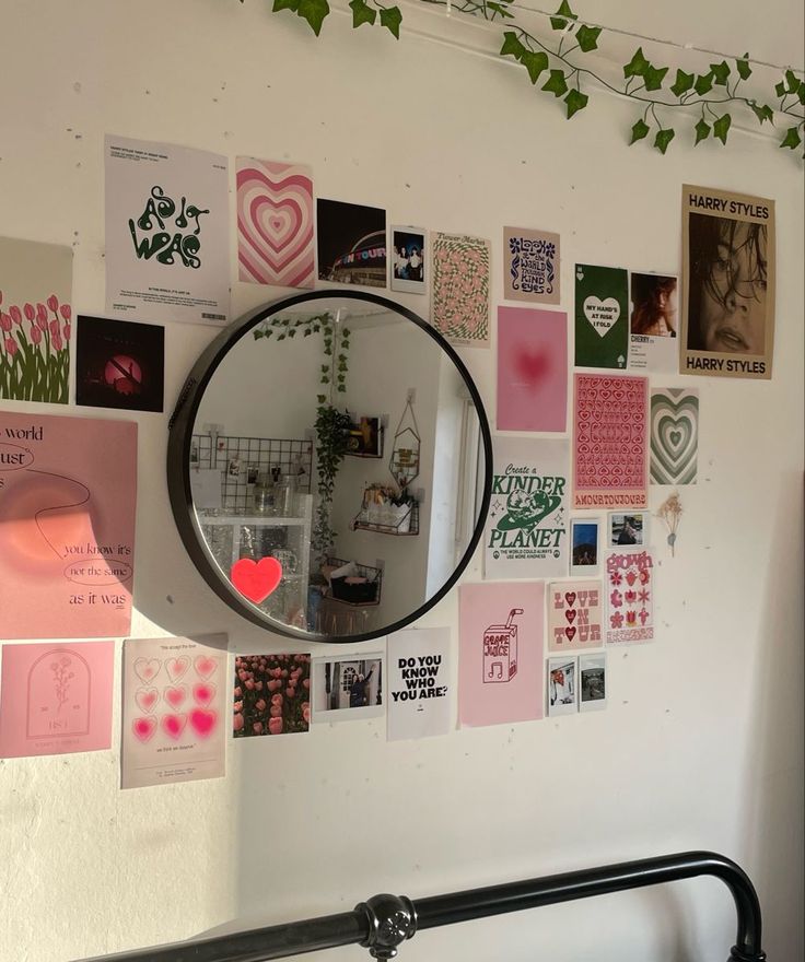 a mirror hanging on the side of a wall covered in pictures and magnets next to a plant