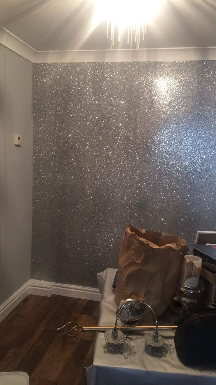 a room that has some silver glitter on the walls and wood flooring in it