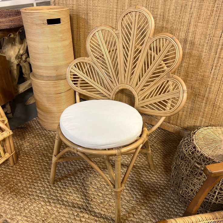 a wicker chair with a white cushion in front of other wicker furniture and baskets