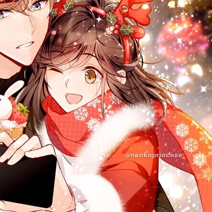 two people are hugging in the snow with christmas decorations on their head and one is holding an apple