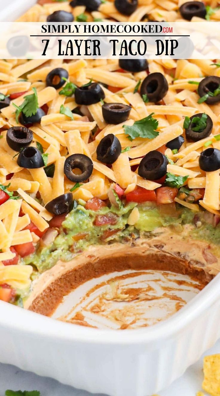 a casserole dish filled with cheese, black olives and tortilla chips