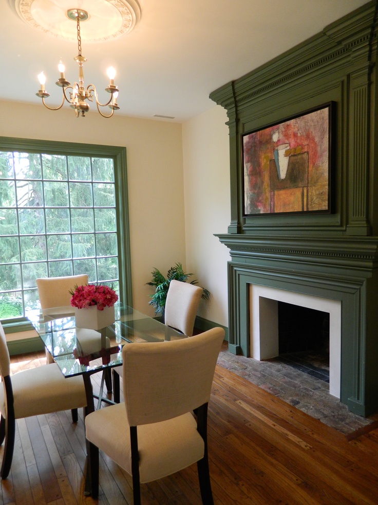 a dining room table and chairs with a fireplace in the corner next to it on a hard wood floor