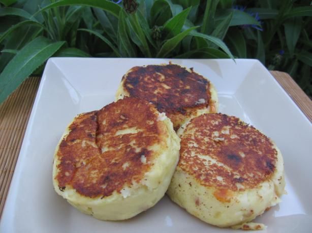 three pancakes sitting on top of a white plate next to green plants and flowers in the background