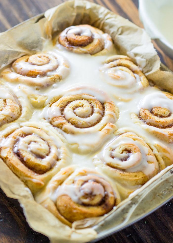 a pan filled with cinnamon rolls on top of a wooden table