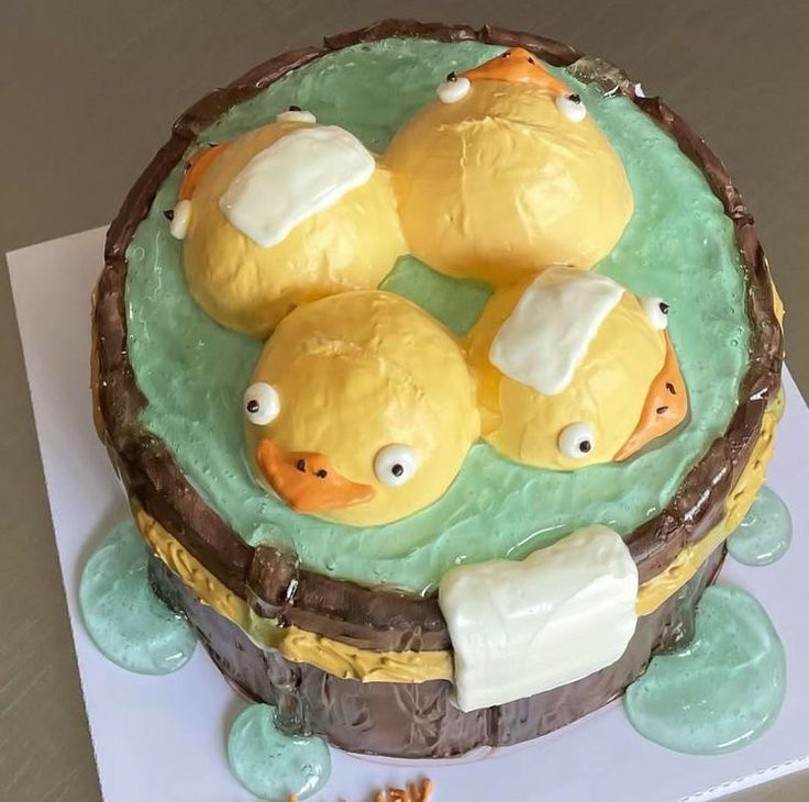 there is a cake decorated with three yellow ducks in the water on top of it