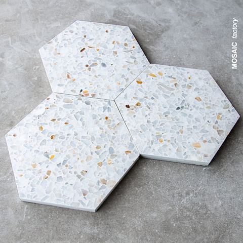 three pieces of white marble with gold and silver speckles on them, arranged in the shape of hexagonal tiles