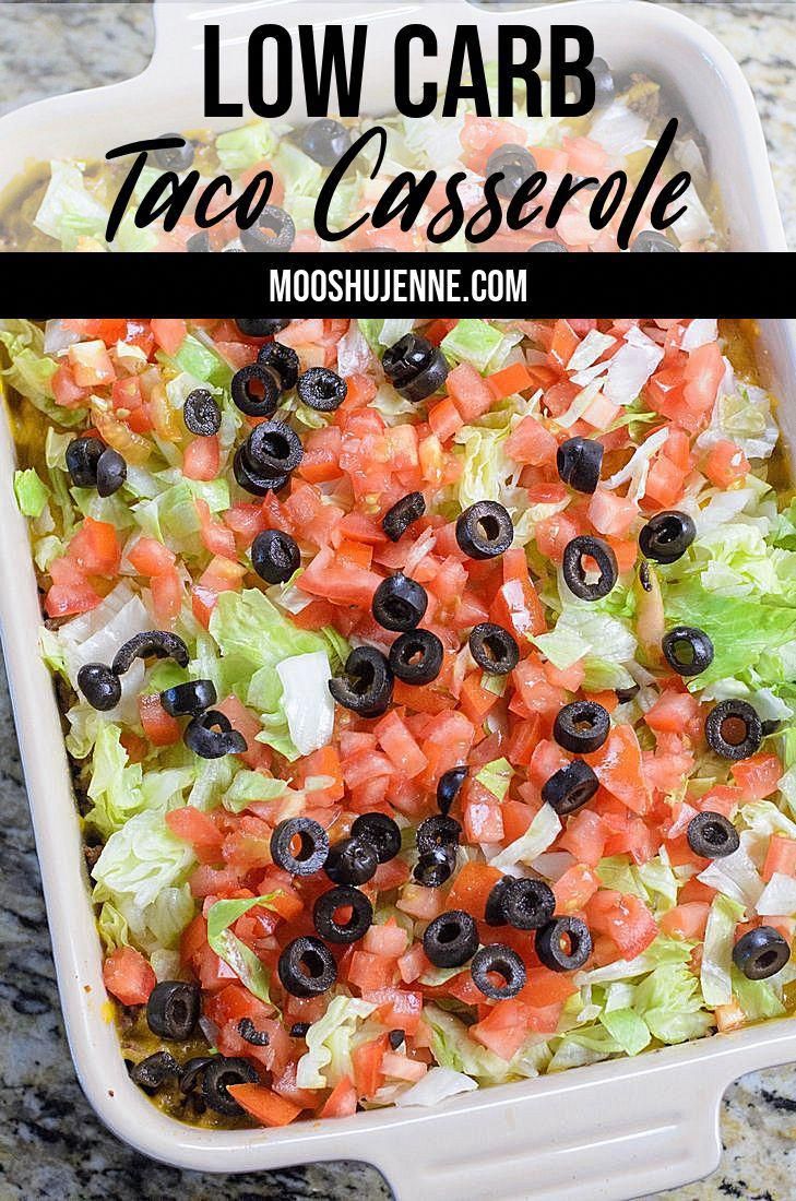 a white casserole dish filled with lettuce, black olives and tomatoes