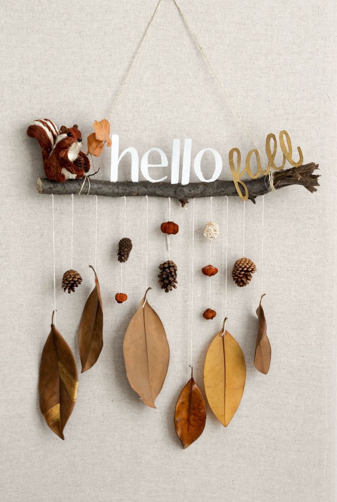 a wooden sign that says hello fall hanging from a branch with leaves and acorns