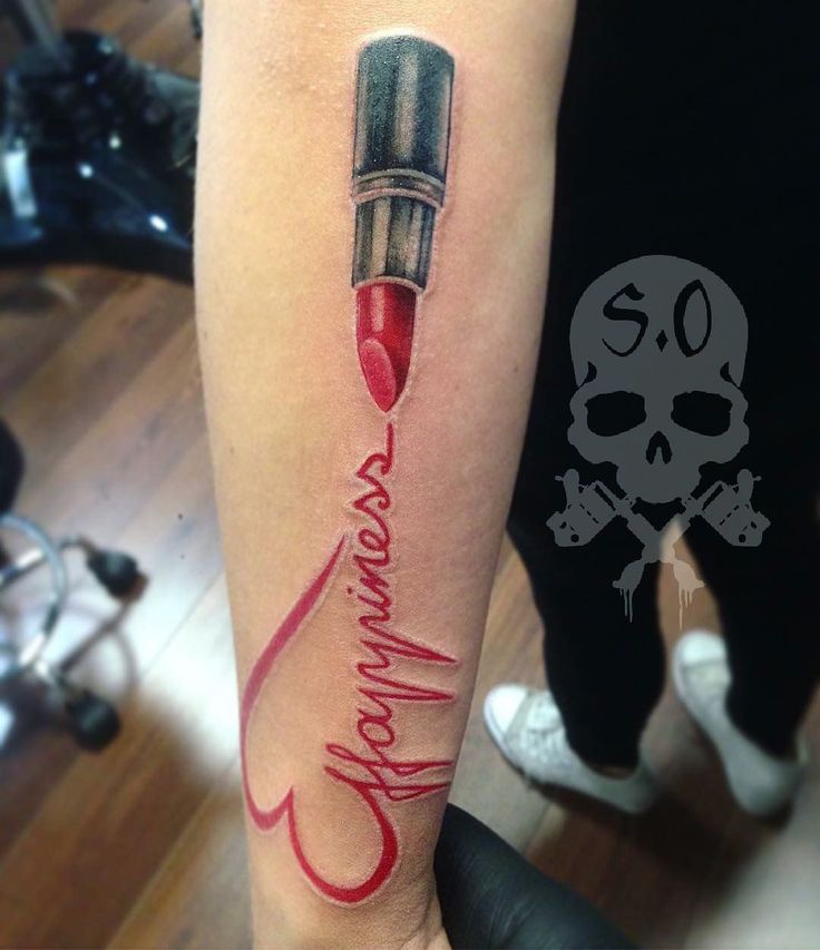 a person with a tattoo on their arm has a red pen and skull in the background