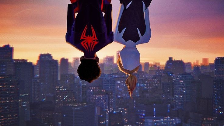 two spider - man hanging upside down in front of a cityscape at sunset