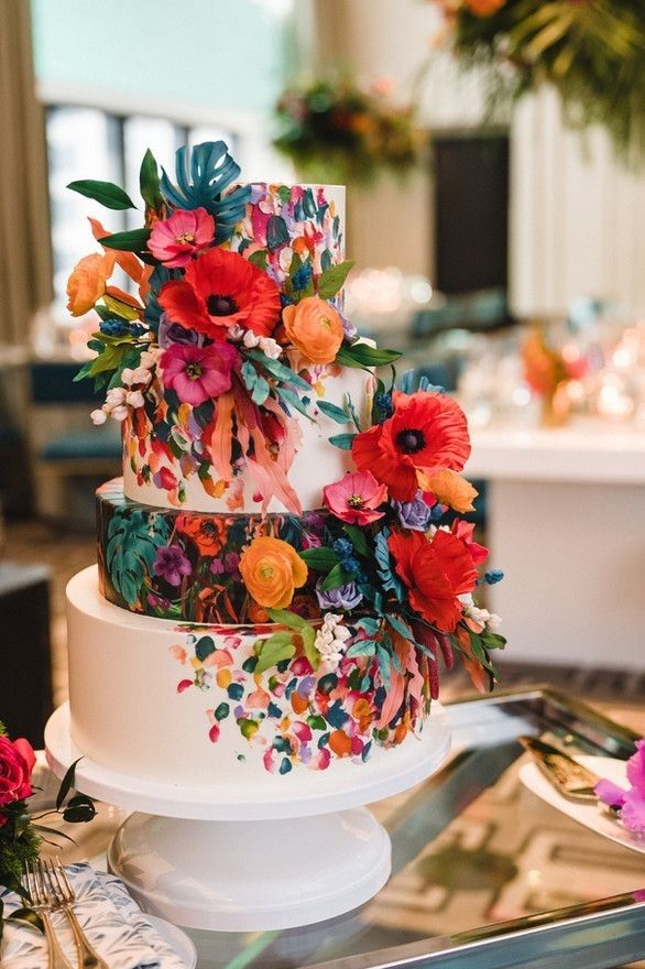 a multi - tiered cake decorated with colorful flowers