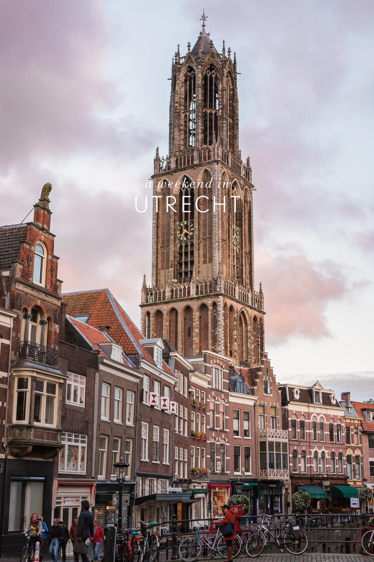 a tall tower with a clock on it's side in the middle of a city