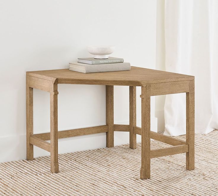 a small wooden table with two books on top