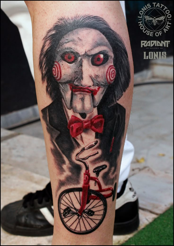 a man's leg with a creepy clown riding a bike