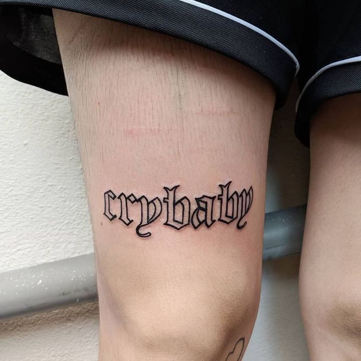 a person with a tattoo on their leg that says crynhallu in cursive writing