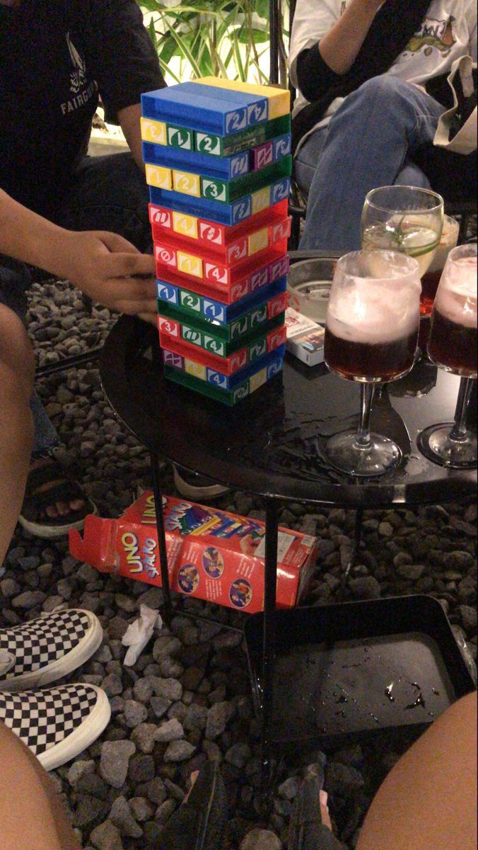 a stack of boxes sitting on top of a table next to two people eating food