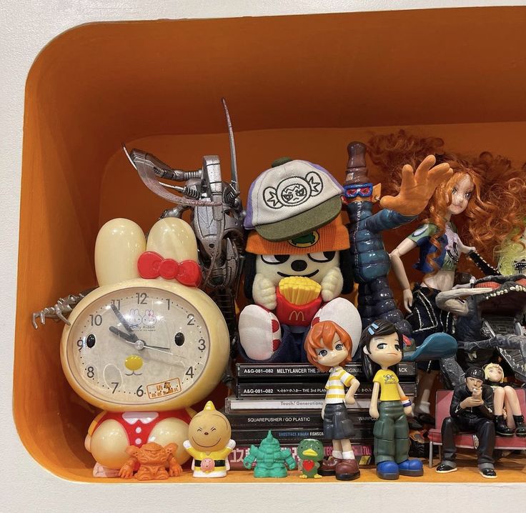 an assortment of toys and figurines are displayed in a toy display case on a shelf