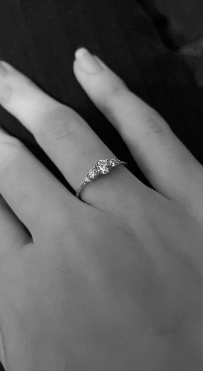 a woman's hand with a diamond ring on top of her left hand, black and white photo