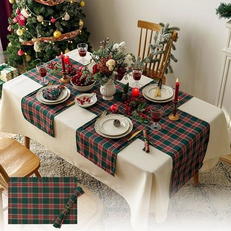 a table set for christmas dinner in front of a tree