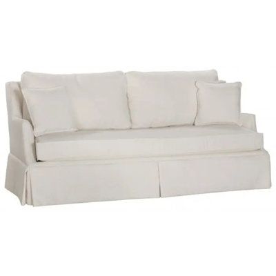 a white couch with two pillows on it's back and one arm folded down