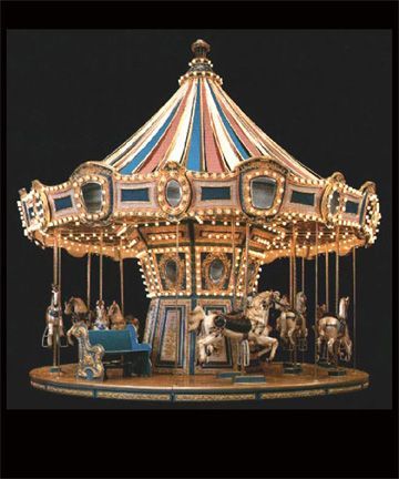 a merry go round carousel with horses and people on the top, in front of a black background