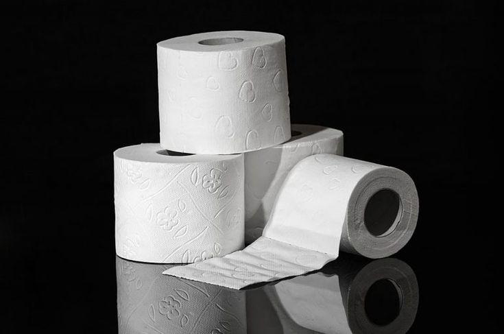 three rolls of toilet paper stacked on top of each other in front of a black background