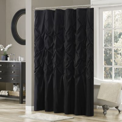 a black shower curtain in a bathroom next to a window