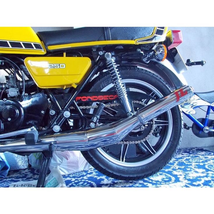 a yellow motorcycle parked next to a blue and white carpeted floor in front of a wall