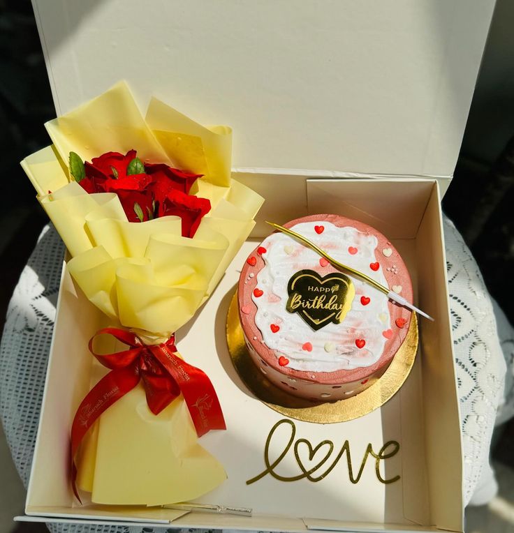 two cakes in a box with red bows on the top and one has a piece of cake