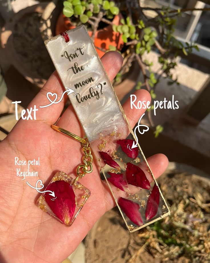 a hand holding a piece of glass with red flowers in it and the words text next to it