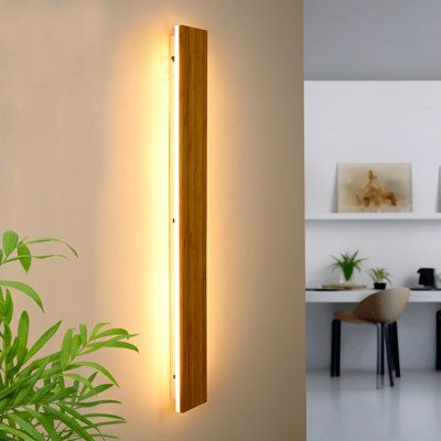 a wall light that is next to a plant