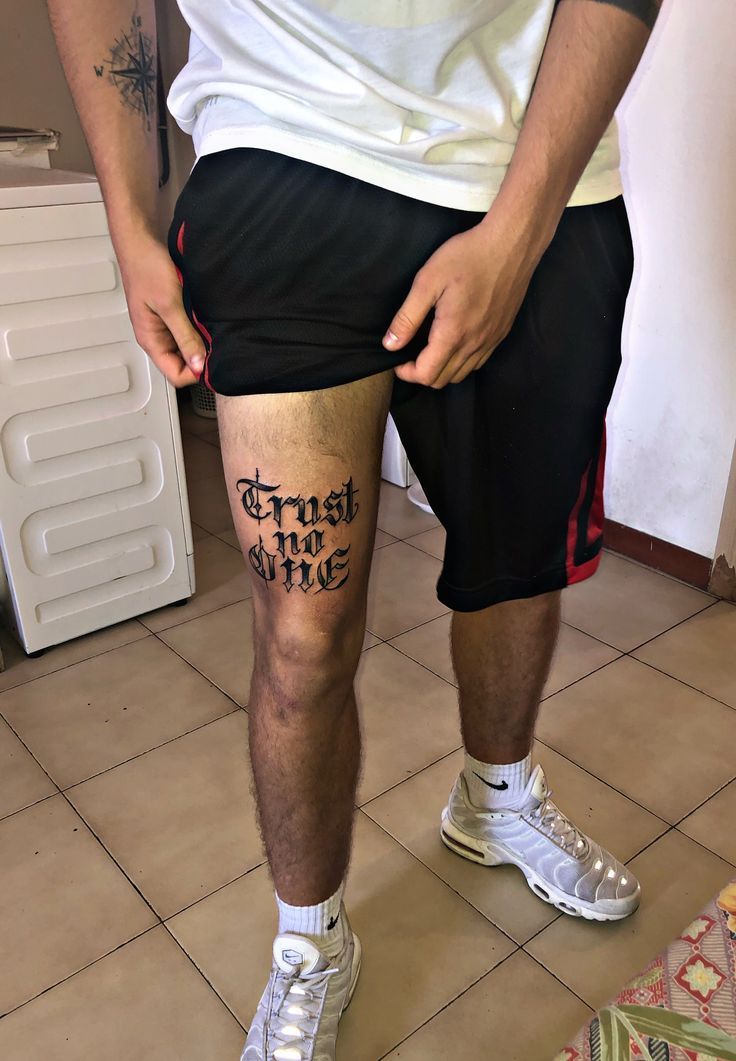 a man with tattoos on his legs and knee