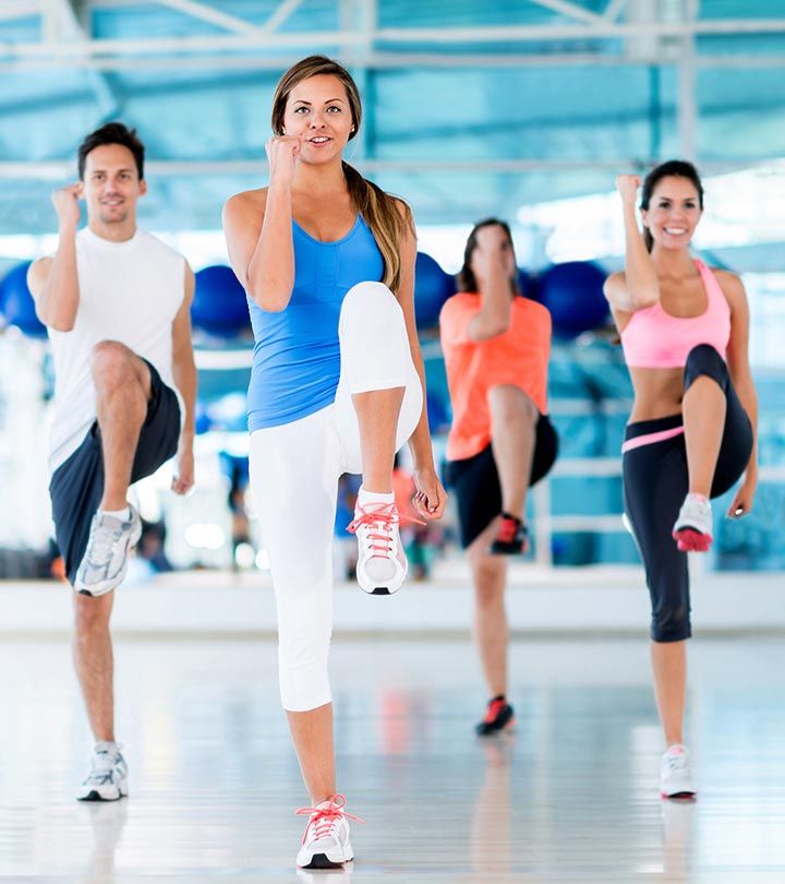 a group of people doing exercises in a dance studio with one woman on her cell phone