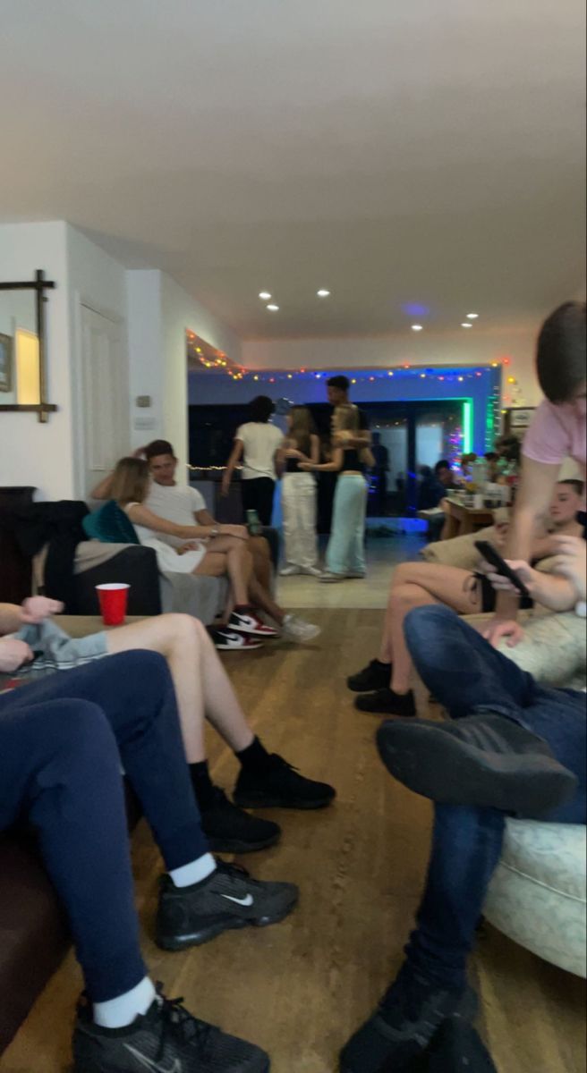 a group of people sitting on couches in a living room next to each other