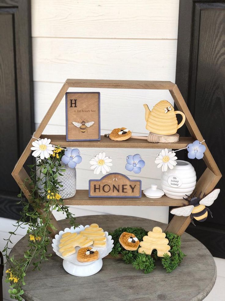 there is a honey display on the table with flowers and other things to eat out of it