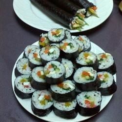 two plates with sushi and carrots on them