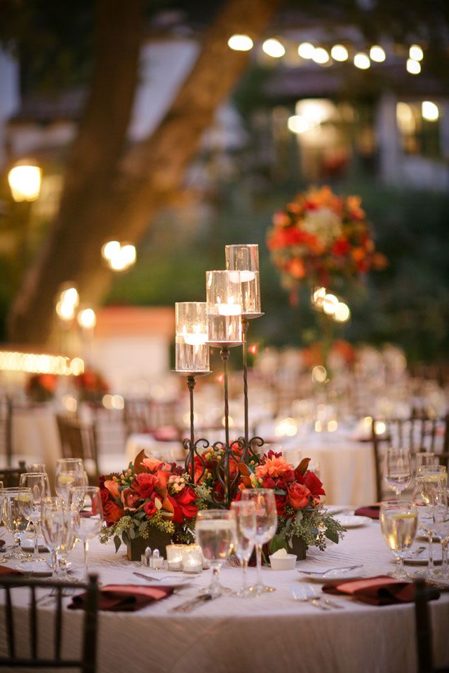 a table is set up with candles and flowers for an elegant wedding reception in the garden