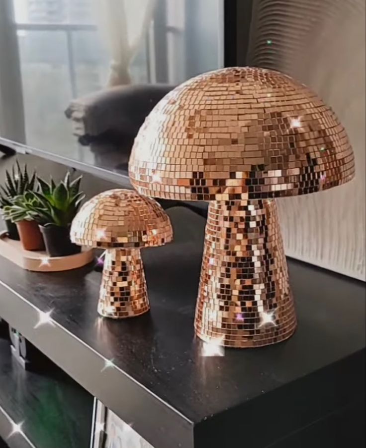 a shiny mushroom lamp sitting on top of a table next to a potted plant