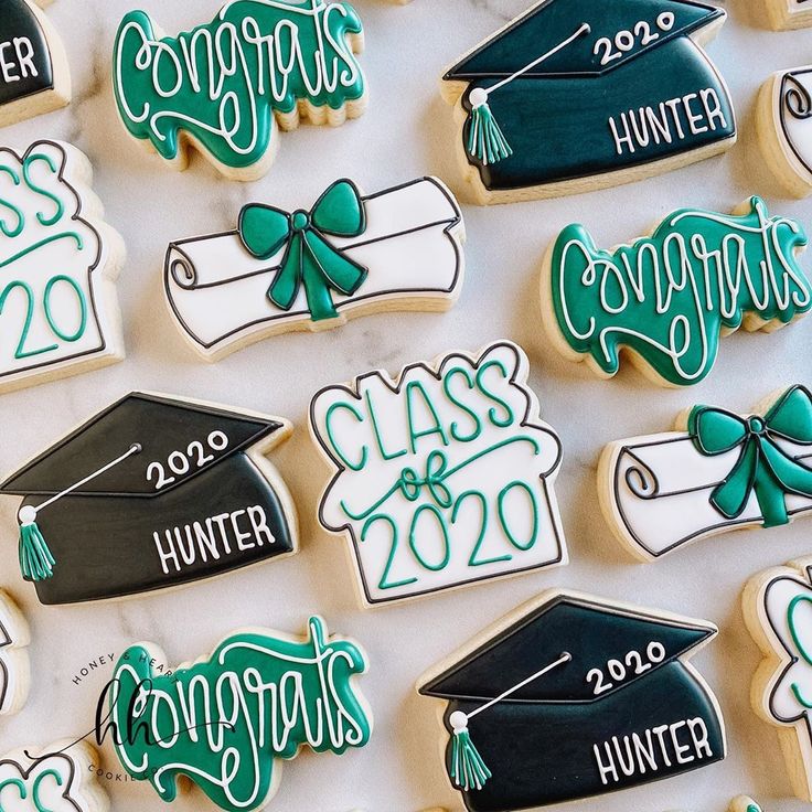 decorated cookies with graduation caps and diplomas are displayed on a white tablecloth that says congrats, class of 2020