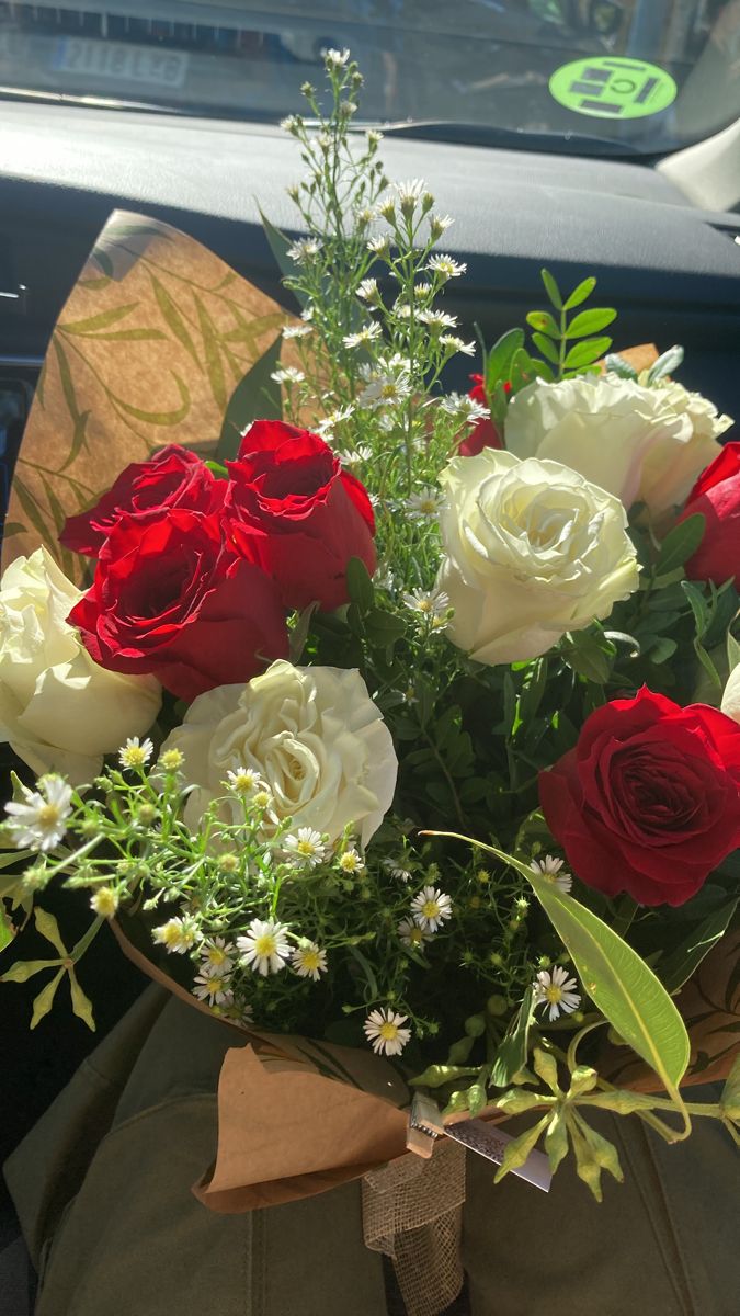 a bouquet of red and white roses in a car