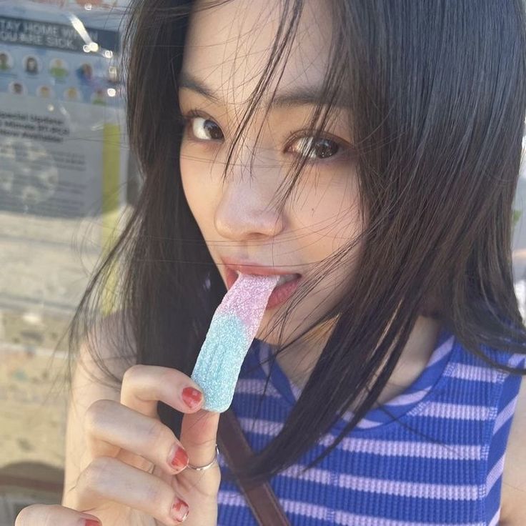 a young woman brushing her teeth with an ice cream bar in front of her face