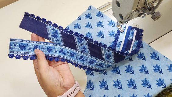 someone is using a sewing machine to sew something blue and white with leaves on it