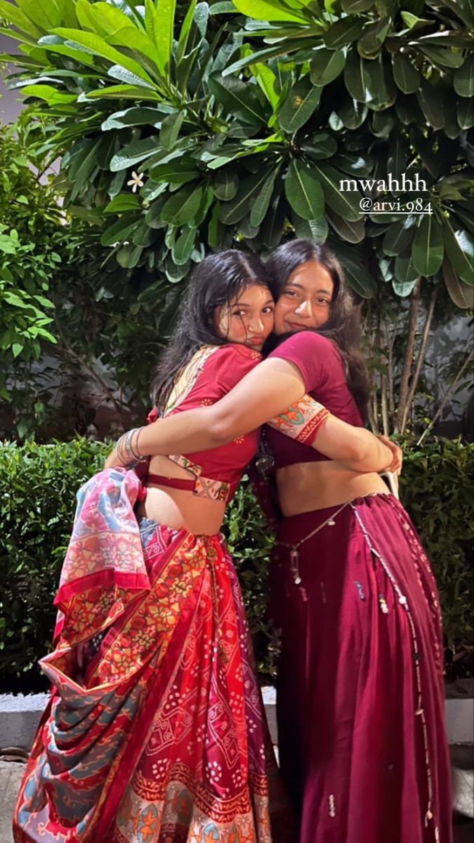 two women in sari hugging each other