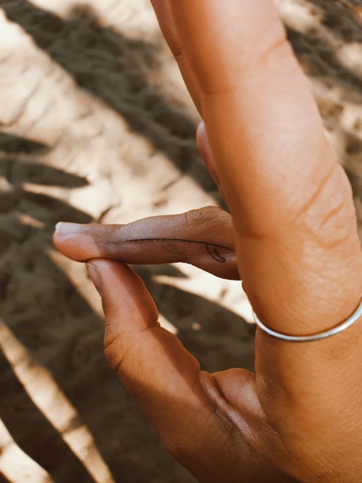 a woman's hand holding onto the tip of her finger