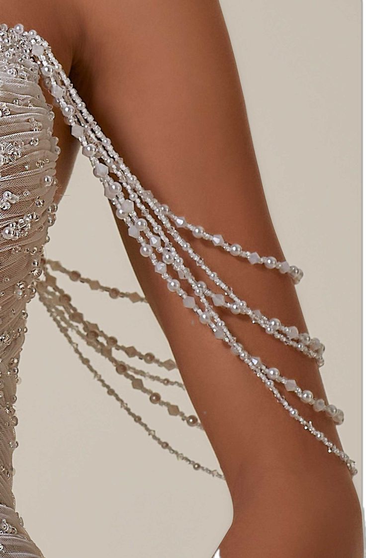 a close up of a woman's dress with pearls on the bottom and side