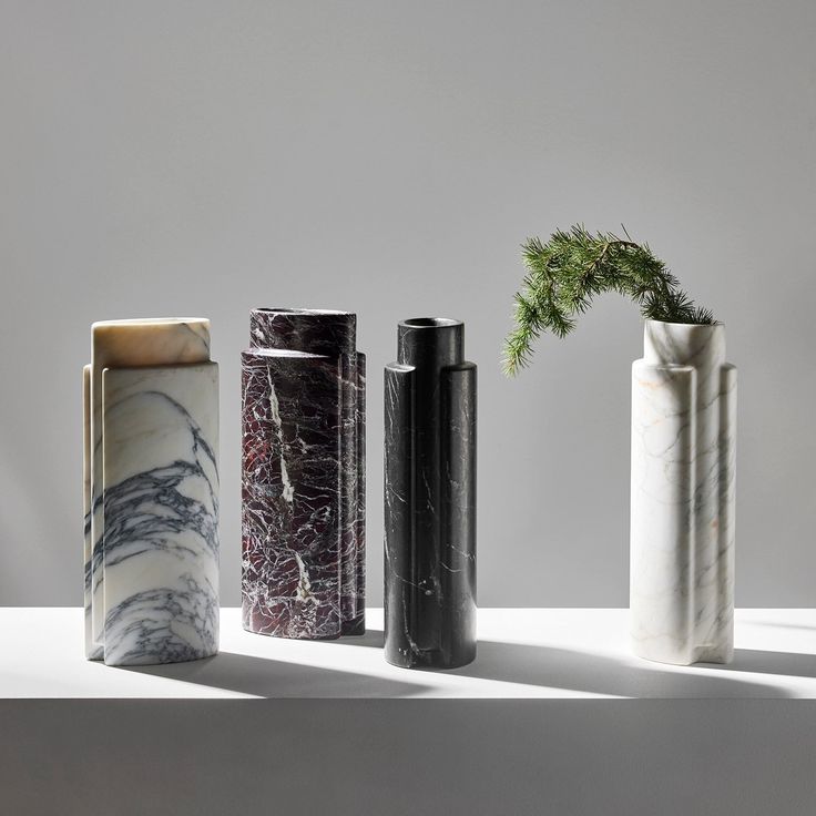 four different types of vases sitting on top of a white table next to each other